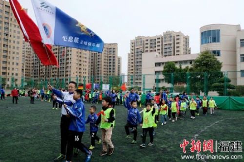 国歌声中，来自福州麦顶小学、施程小学的孩子们与心启航足球俱乐部的“星娃”手牵手步入足球场。黄磊 摄